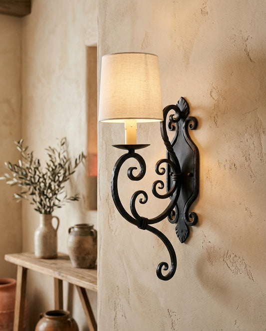 Applique murale en fer forgé à volutes avec abat-jour lin, mur beige, lumière tamisée