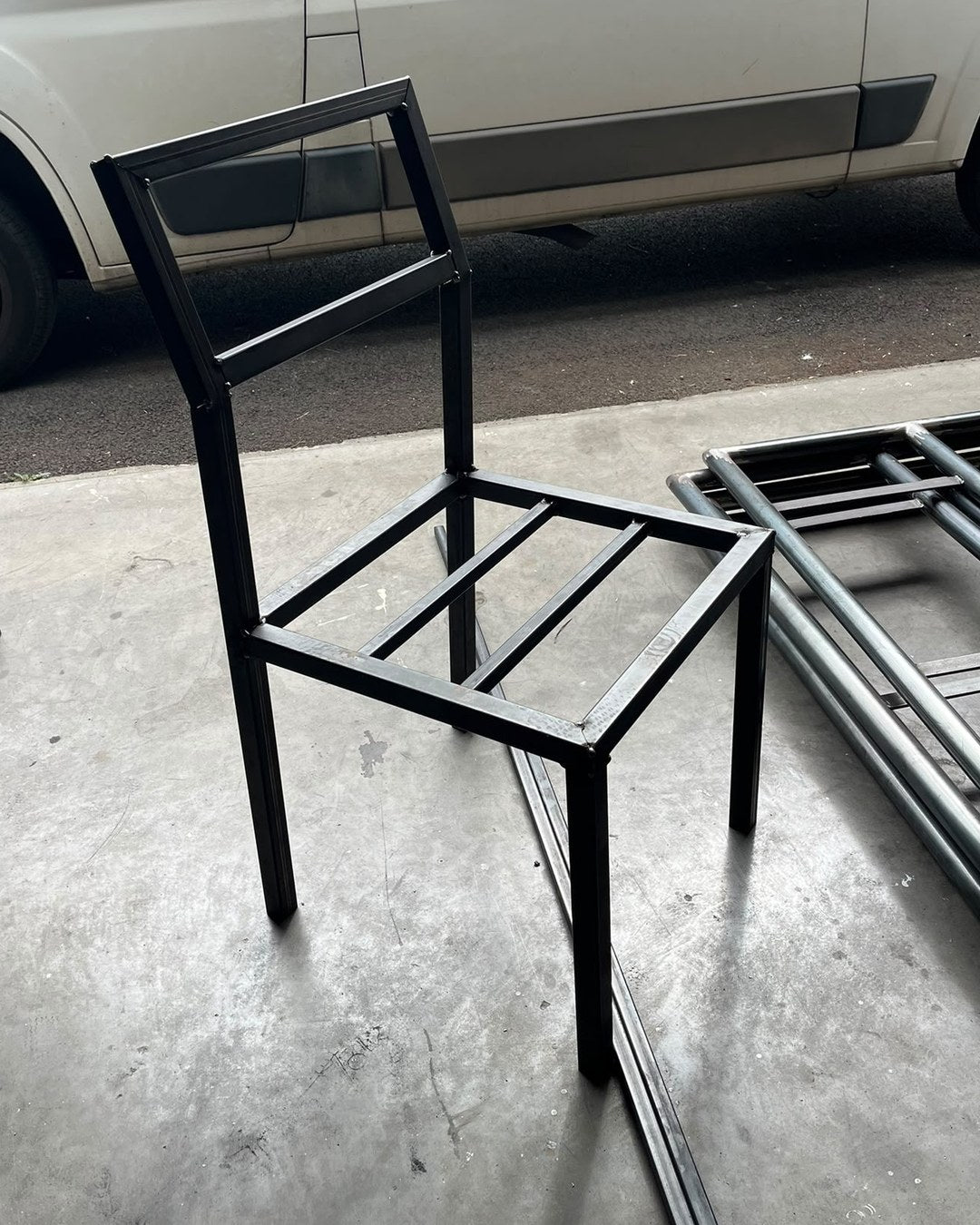 Chaise Épure en cours de fabrication à l'atelier, septembre 2026 : structure après peinture noir mat, avant garnissage