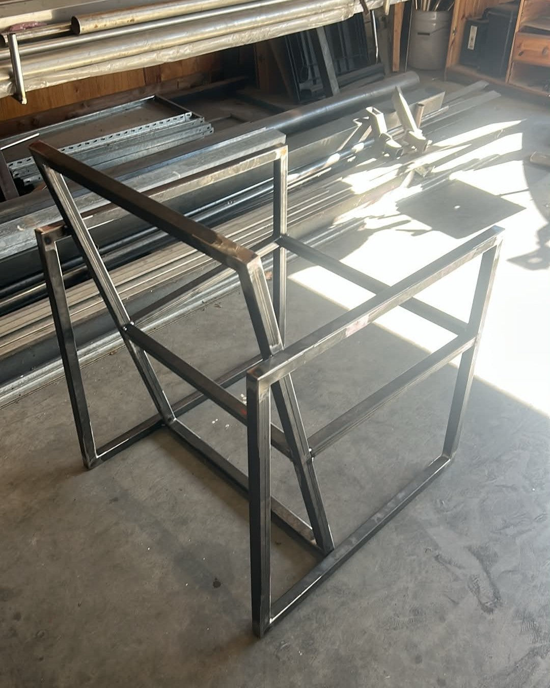 Fauteuil Épure en cours de fabrication à l'atelier, septembre 2026 : structure en acier vue de côté, avant finition et garnissage