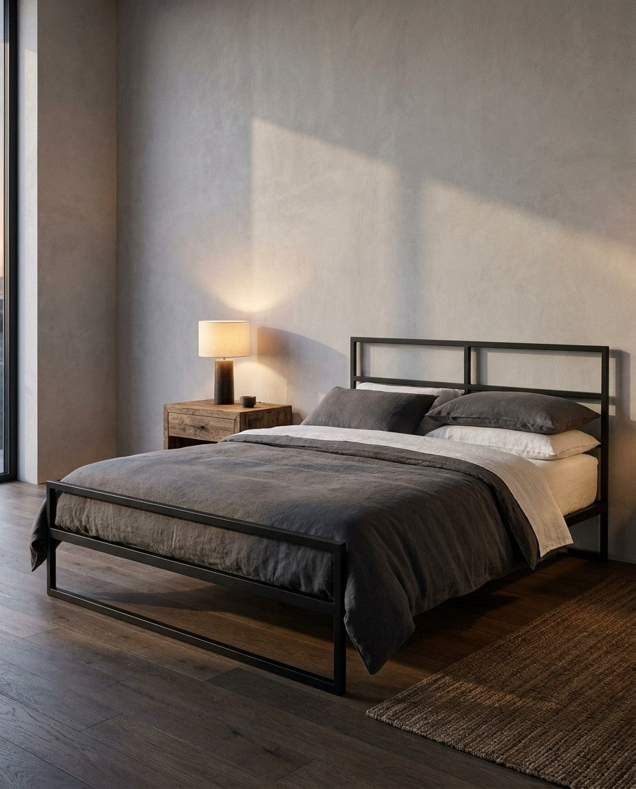 Lit Épure en acier noir mat dans un loft, lumière du soir