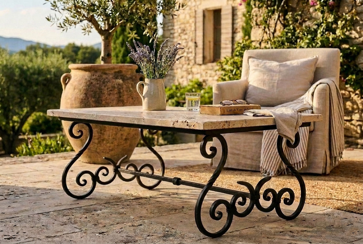Table basse en fer forgé à volutes, plateau travertin, sur une terrasse méditerranéenne — Mon Siège Personnalisé